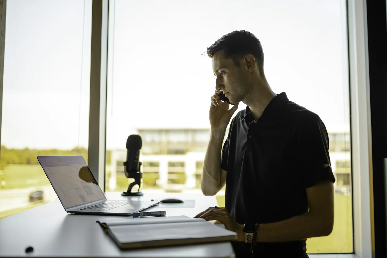 Un professionnel au téléphone consulte un tableau de bord sur son ordinateur portable