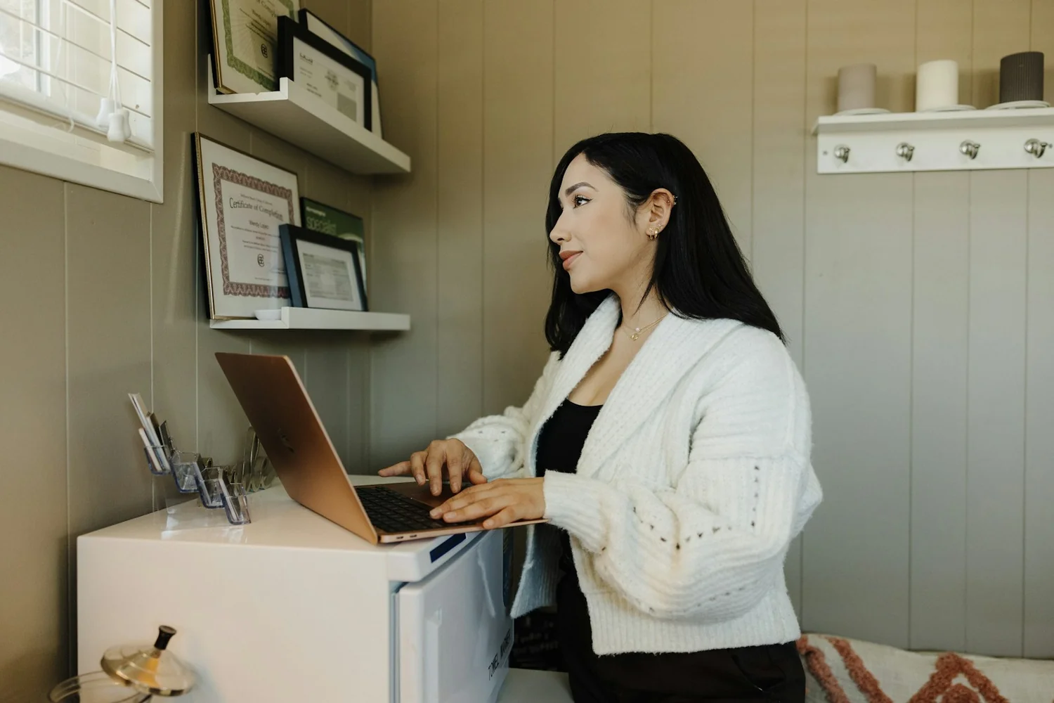 Une indépendante travaille sur son ordinateur portable dans son atelier, pour gérer son compte pro et sa comptabilité