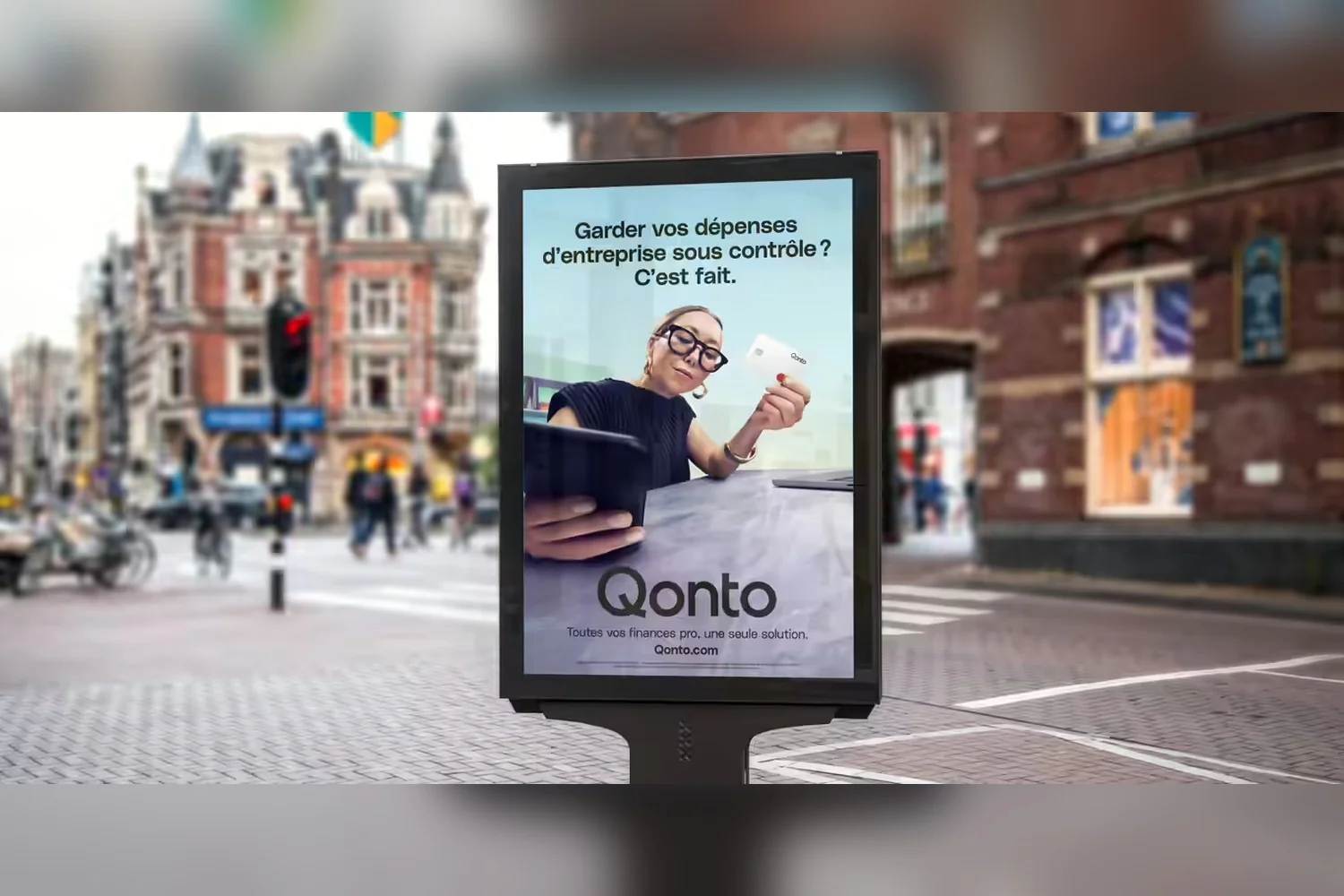 Affiche de la campagne Qonto « Garder vos dépenses d'entreprise sous contrôle ? C'est fait. » dans une rue